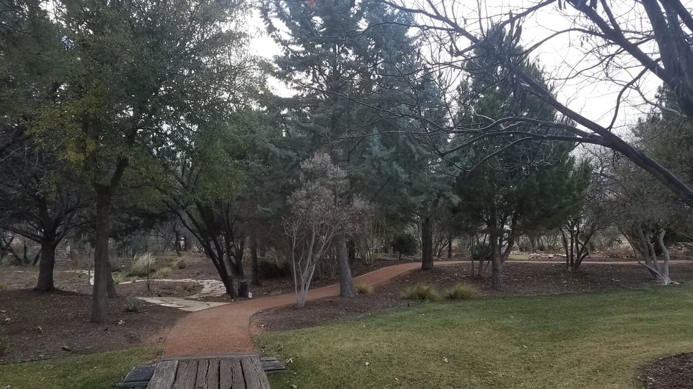 gravel path meets wood bridge at Gage Gardens
